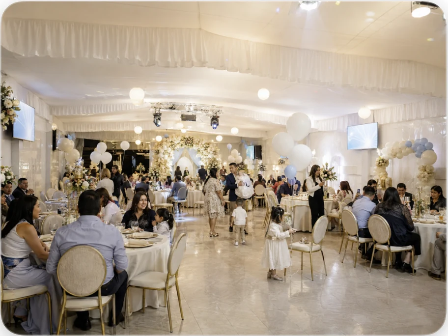 Bautizo familiar en salón decorado con mesas, invitados y niños