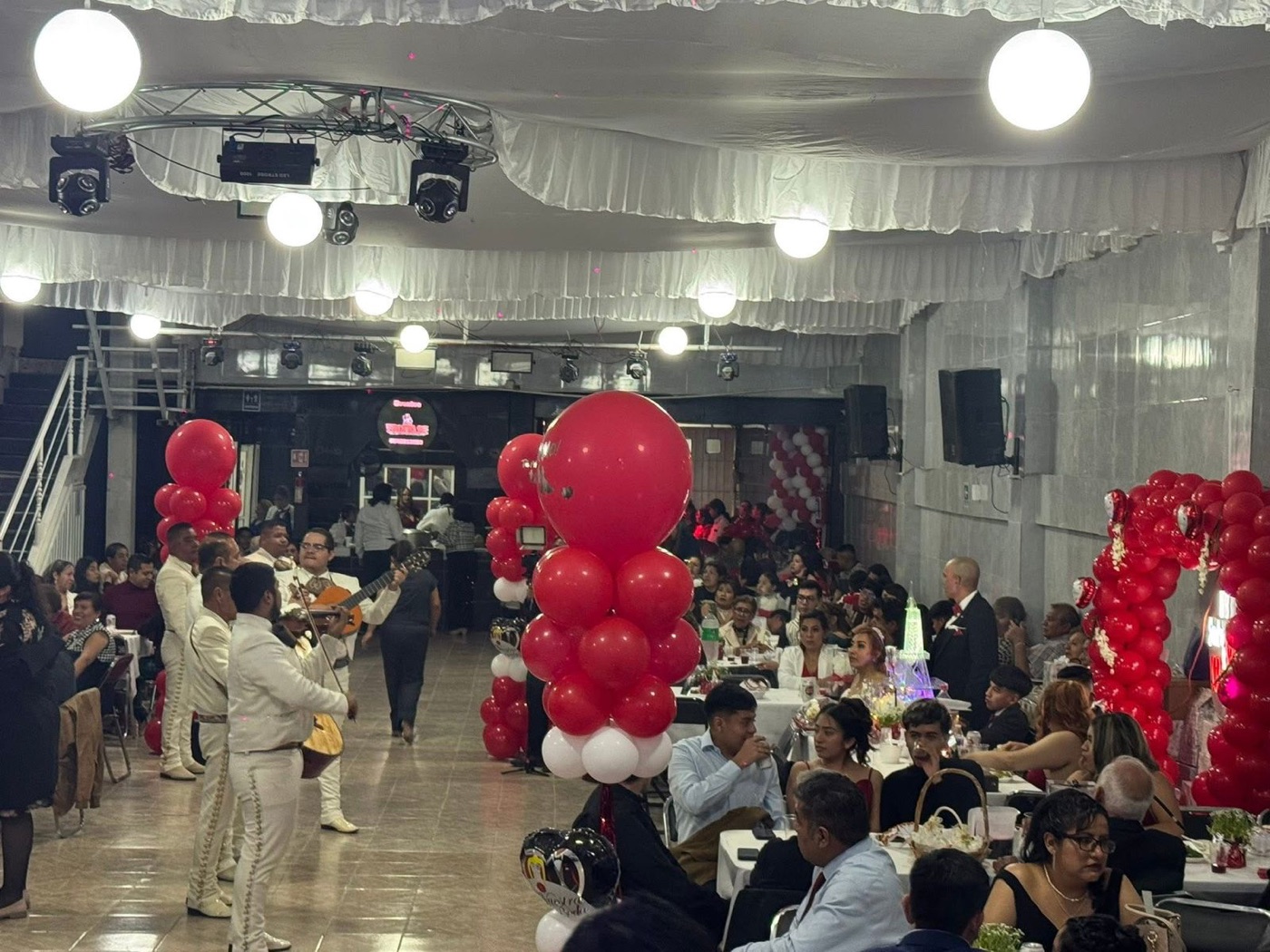 Fotografia real de Salón Mr Diablo lleno durante una boda con mariachi y montaje rojo